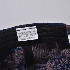 Macro shot of 100% polyester wash label inside the denim baseball cap showing fabric care