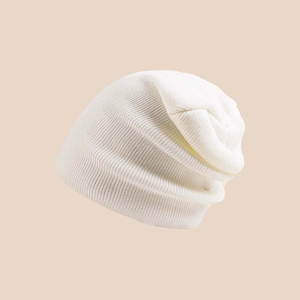 Detailed close-up showing the fine knit texture and soft fabric of the white winter beanie