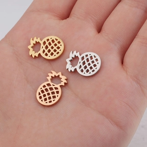 Detailed macro view of pineapple jewelry pendants in gold silver and rose gold metal