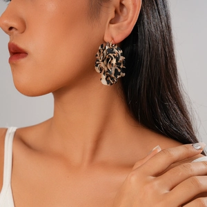 Close-up of leopard print fabric flower earrings worn by a model for a stylish retro look