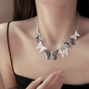 Detail of silver butterfly choker necklace with black inlay and intricate hollow wing design