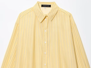 Dettaglio del colletto della camicia a righe gialle e bianche con etichetta taglia XS e tessuto