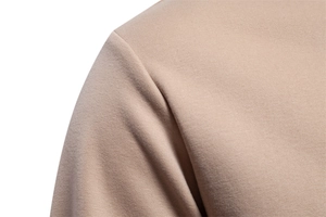 Macro detail of high-quality shoulder stitching on a khaki loose-fit crewneck sweatshirt