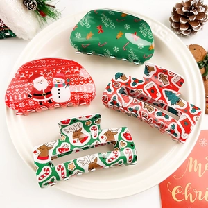 Gros plan de quatre pinces à cheveux de Noël festives en rouge et vert avec motifs variés