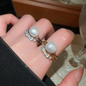 Detailed close-up of baroque pearl rings with zircon accents on hand for an elegant look