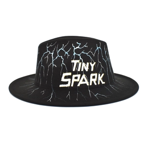 Close-up of hand-painted lightning pattern and TINY SPARK text on black wool fedora