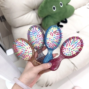 Four mini glitter hairbrushes in gold, blue, pink and silver with colorful massage bristles