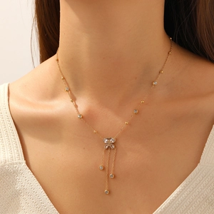Collier papillon doré avec pampilles en cristal et breloques rondes sur un mannequin