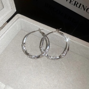 Macro shot of twisted silver earrings with pavé zircons in a velvet jewelry box