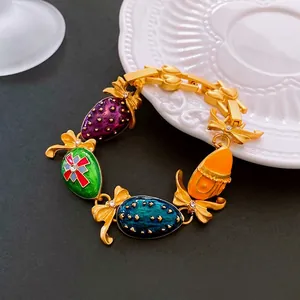 Vintage style gold bracelet with colorful enamel charms and sparkling crystal bows