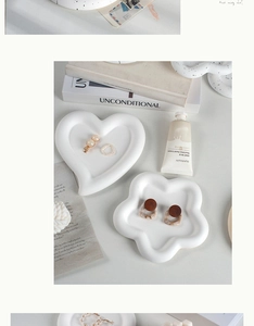 Top view of matte white ceramic heart and flower jewelry trays with minimalist styling