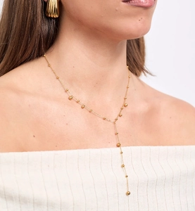 Détail d'un long collier en Y doré avec de petites perles porté par un mannequin