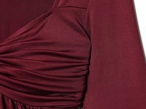 Detailaufnahme des weinroten Strickoberteils mit eleganter Raffung und Plisseedetails