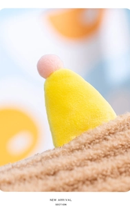 Detailed macro view of yellow decorative cone with a soft pink pompom on plush fabric