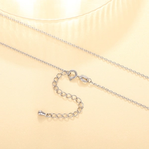 Detailed macro view of silver cross chain lobster clasp and adjustable droplet pendant