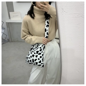 Mirror selfie showing a plush cow print crossbody bag with autumn winter casual style