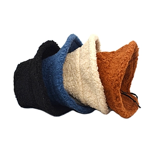 Détail de quatre bobs en laine d'agneau duveteuse en noir bleu beige et marron