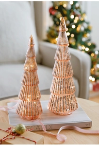 Detail view of two rose gold ribbed glass Christmas trees with metallic finish