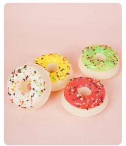 Vue macro de quatre donuts artificiels en PU chocolat avec des pépites de sucre colorées