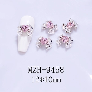 Detail of silver alloy bow nail charms with pink heart rhinestones, size 12x10mm