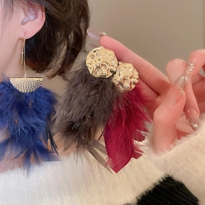 Detail of bohemian gold hammered stud earrings with vibrant feather tassels in multiple colors