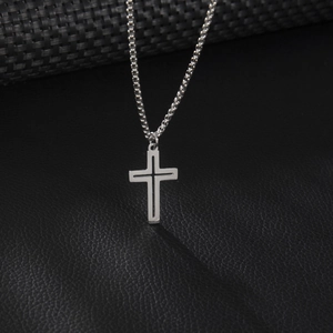 Minimalist silver hollow cross pendant necklace on a sleek black leather texture background