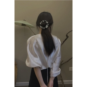 Close-up of a vintage Chinese hair slide with mother of pearl inlay and black embroidery