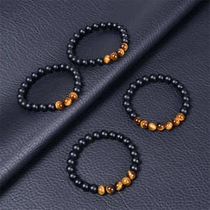 Détail macro de perles naturelles en œil de tigre et agate noire mate sur cuir