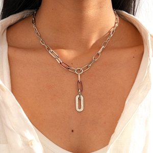 Detail of silver Y-shaped necklace with paperclip chain and red enamel diamond accents