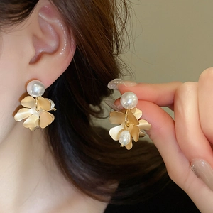 Detailed view of vintage gold flower earrings with freshwater pearl accents for women