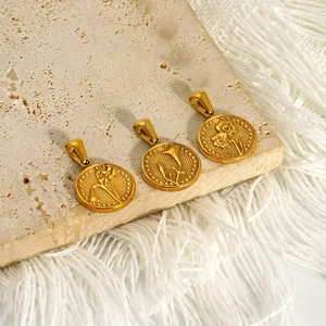 Three gold vintage floral coin pendants with embossed patterns on stone background