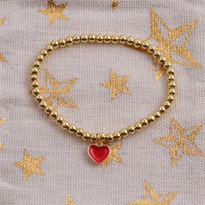 Detailed top view of a gold beaded elastic bracelet with a red heart enamel pendant