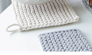 Detailed macro view of woven cotton rope placemats with loops in white and grey colors