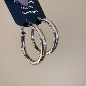 Polished silver metal hoop earring with mirror finish shown on an export display card