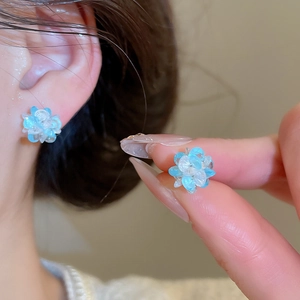 Macro view of blue floral stud earrings featuring translucent gradient resin petals