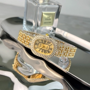 Close-up of luxury gold ladies' watch with rhinestones on a reflective wave surface