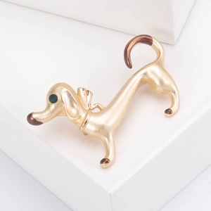 Detail of dachshund brooch with brown enamel accents and a sparkling green crystal eye