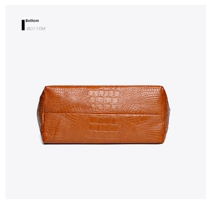 Detailed bottom view of brown crocodile embossed tote bag with high-quality stitching