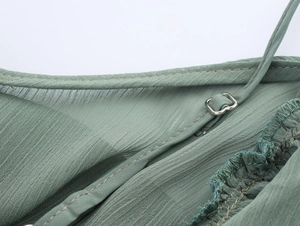 Detail der verstellbaren Träger und Plissee-Chiffon-Stoff eines V-Ausschnitt-Kleides