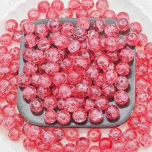 Macro shot of 10mm red glass beads with gold wire silk thread and cracked ice pattern