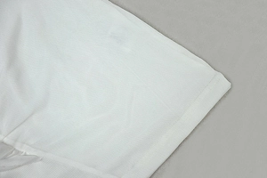 Close-up of white breathable piqué fabric texture on dress hem with high-quality mesh detail
