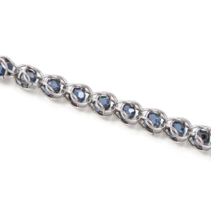 Detailed macro of stainless steel chain links with embedded faceted dark blue beads
