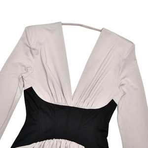 Detail of the plunging backless design with contrast waist panels and textured fabric