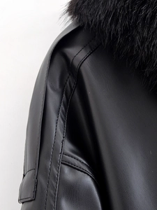 Detailed close-up of the black leather jacket featuring a thick faux fur collar and texture