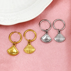 Détail de boucles d'oreilles en éventail or et argent sur tissu rose lustré