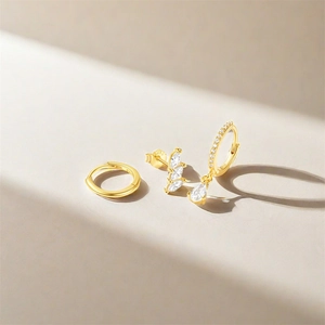 Macro detail of S925 sterling silver gold earrings set with zircon and drop pendant