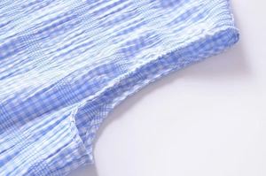 Detail of blue and white plaid fabric texture with pleated design and fine stitching