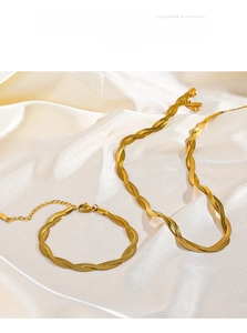 Macro detail of 18K gold plated twisted flat snake chain necklace and bracelet set