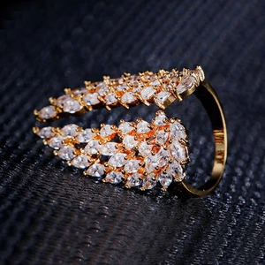 Macro shot of gold wings ring featuring marquise-cut cubic zirconia on a black texture