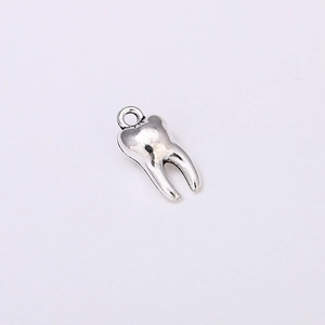 Close-up of a silver metal tooth-shaped charm pendant for DIY jewelry making
